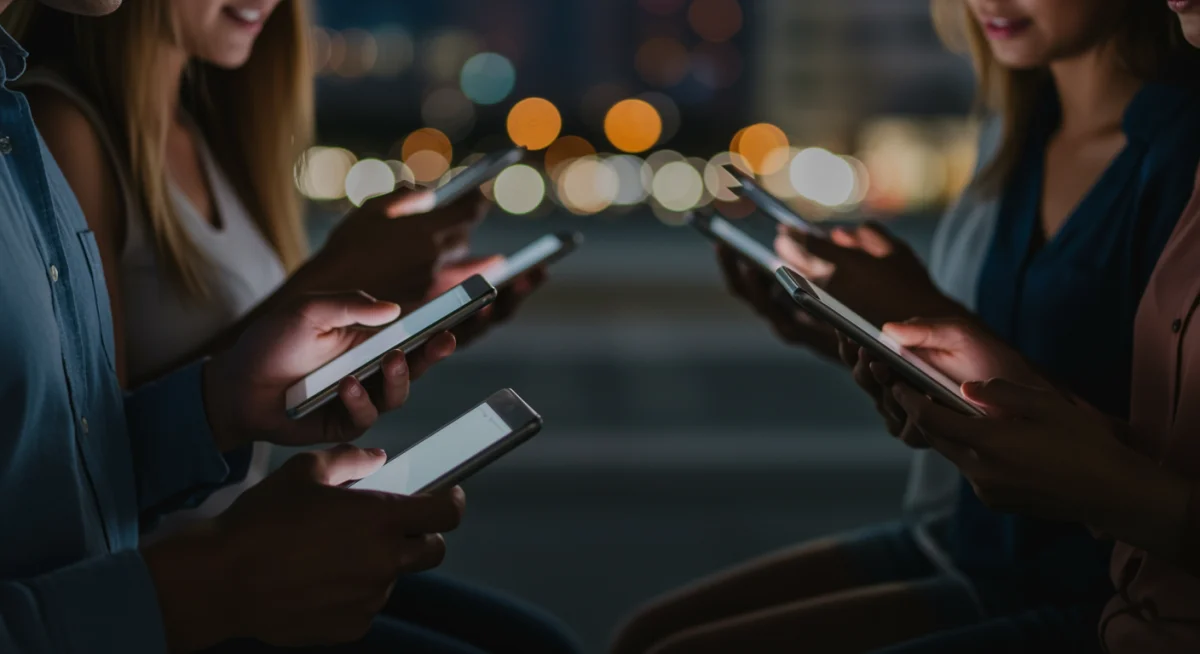 Diverse individuals engaging with mobile devices, reflecting modern digital content consumption.