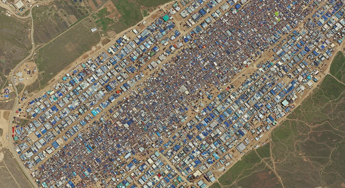 Aerial view of a large refugee camp, highlighting humanitarian challenges